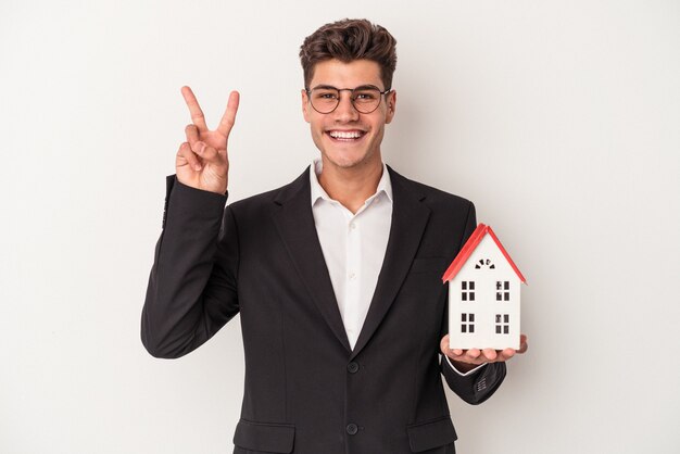 Young real estate caucasian agent isolated on white background showing number two with fingers.