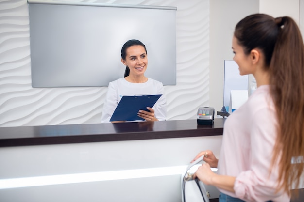 Young receptionist talking to a client in a beauty clinic