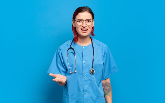 Young red hair nurse looking angry, annoyed and frustrated