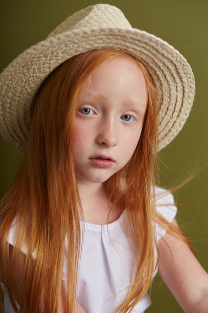 Young red-haired girl in a straw hat 