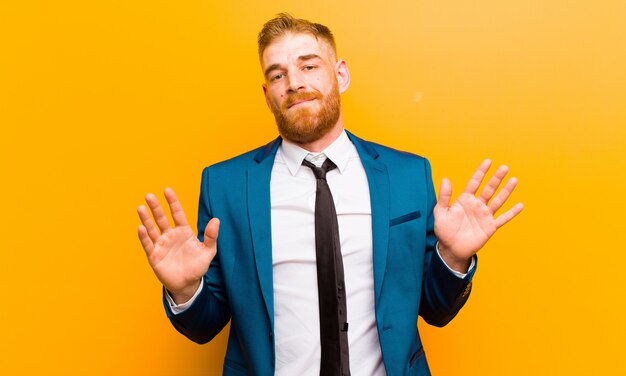 Young red head businessman looking nervous, anxious and concerned