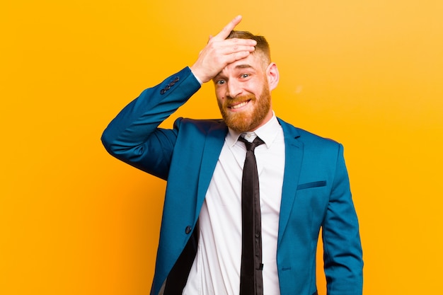 Young red head businessman panicking over a forgotten deadline, feeling stressed, having to cover up a mess or mistake