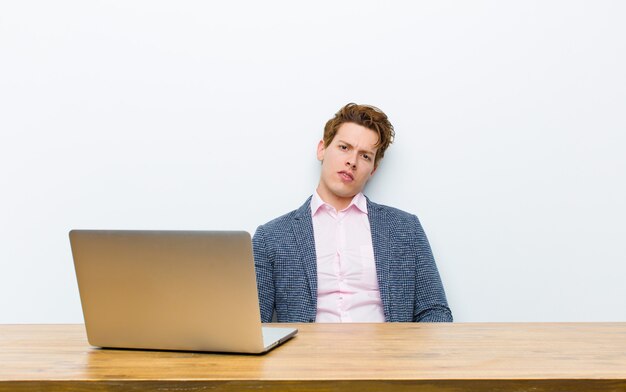 Young red head businessman working in his desk with a laptop