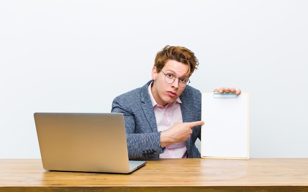 Young red head businessman working in his desk with a sheet of paper