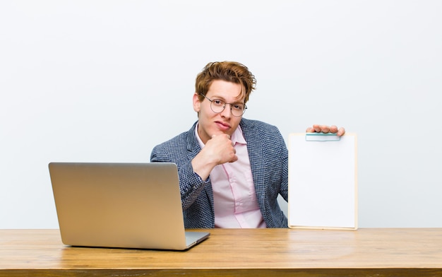 Young red head businessman working in his desk with a sheet of paper