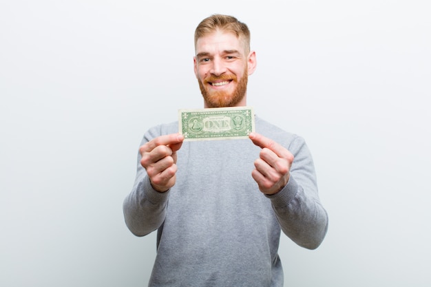 Young red head man with dollars