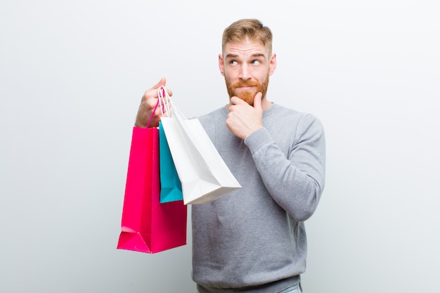 Young red head man with shopping bags