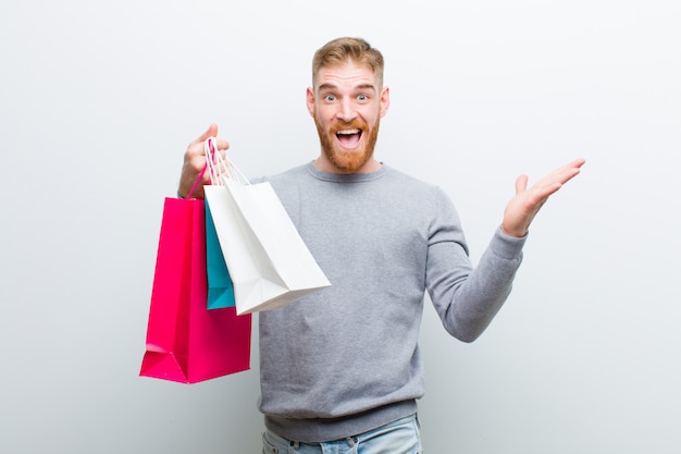 Young red head man with shopping bags