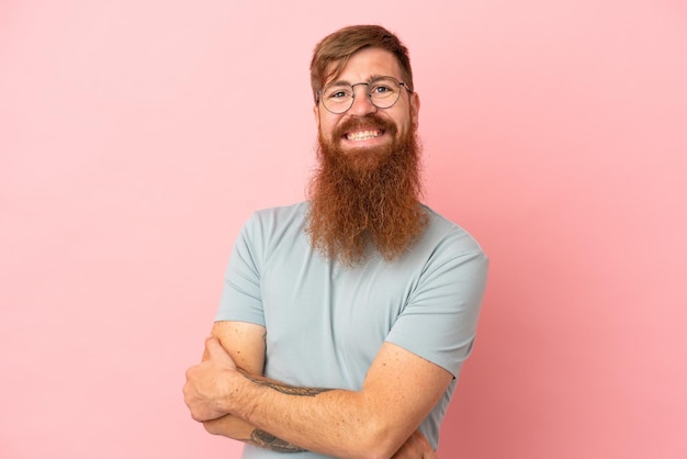 Young reddish caucasian man isolated on pink background laughing