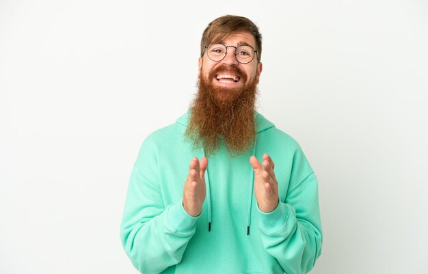 Young reddish caucasian man isolated on white background applauding after presentation in a conference