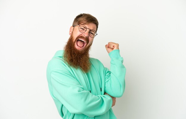 Young reddish caucasian man isolated on white background celebrating a victory