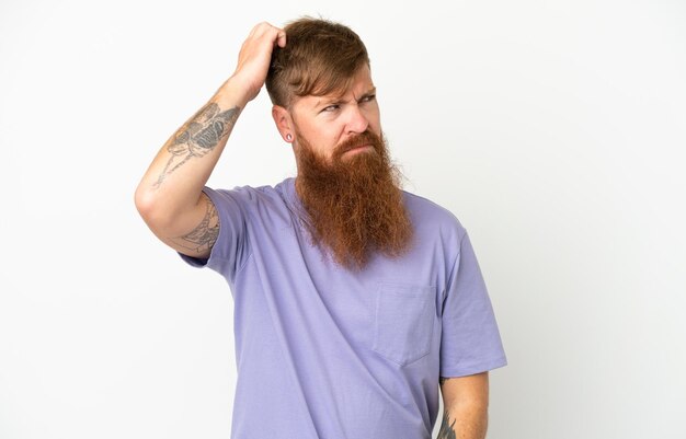 Young reddish caucasian man isolated on white background having doubts while scratching head