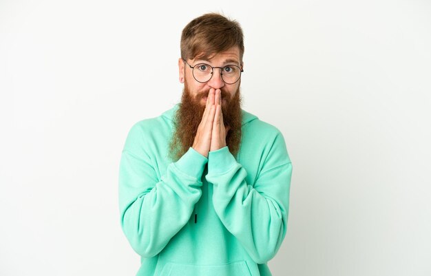 Young reddish caucasian man isolated on white background keeps palm together Person asks for something