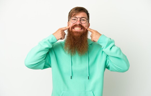 Young reddish caucasian man isolated on white background smiling with a happy and pleasant expression