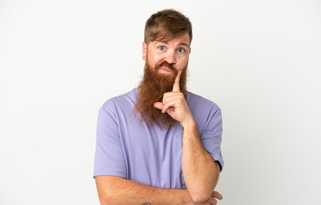 Young reddish caucasian man isolated on white background and thinking