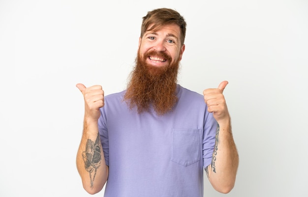 Young reddish caucasian man isolated on white background with thumbs up gesture and smiling