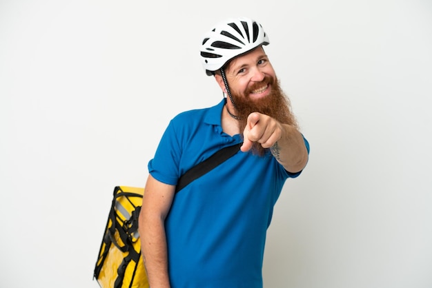 Young reddish caucasian man with thermal backpack isolate don white background pointing front with happy expression