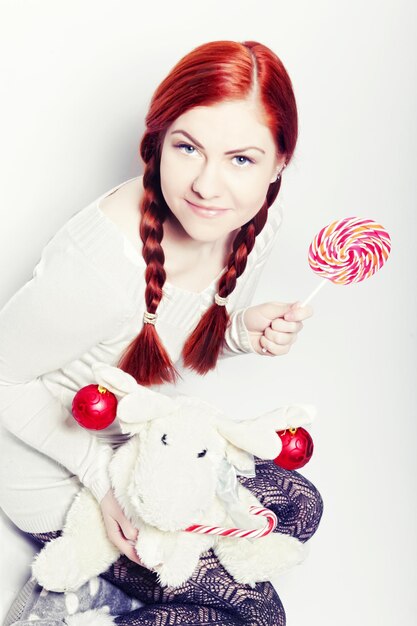 Young redhair woman with deer toy