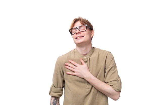 Young redhaired european man dressed in a light brown shirt wears glasses for vision