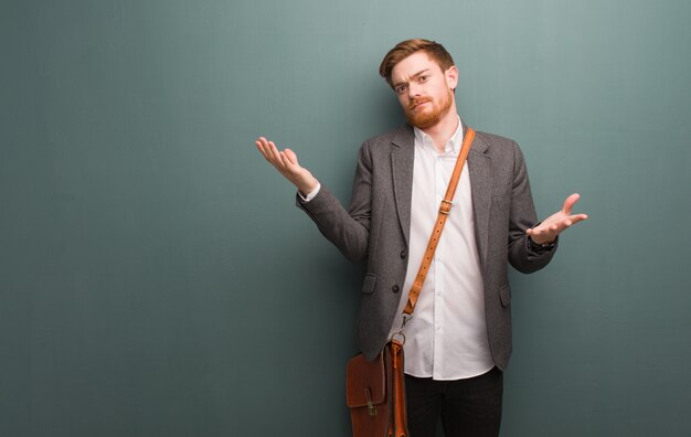 Young redhead business man confused and doubtful