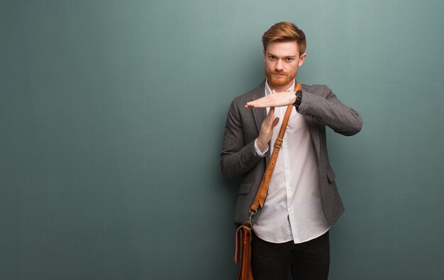 Young redhead business man doing a timeout gesture