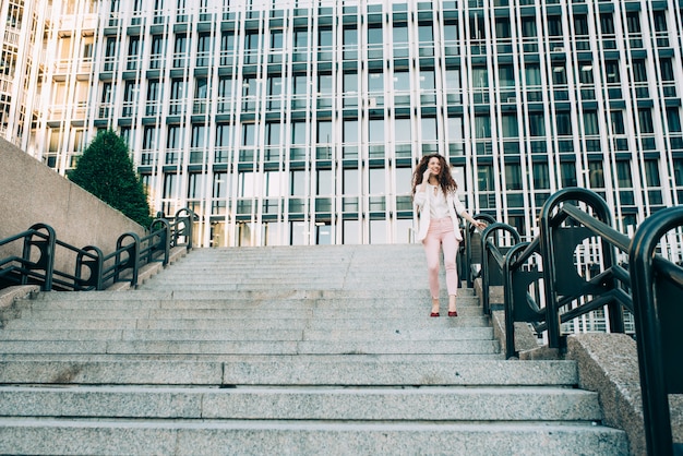 Young redhead business woman walking on the stairs