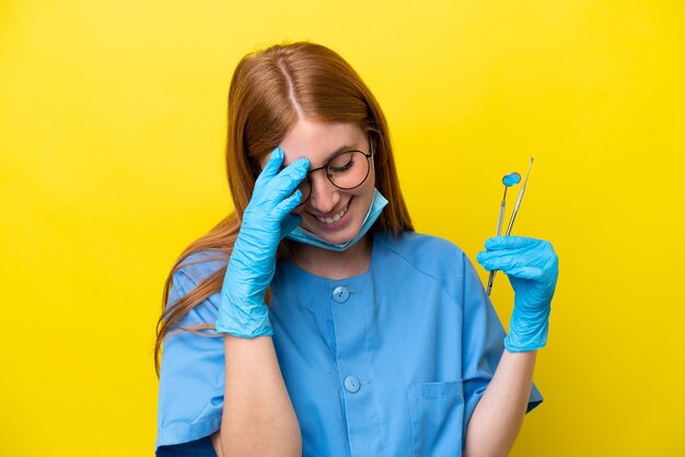 Young redhead Dentist woman isolated on yellow background laughing