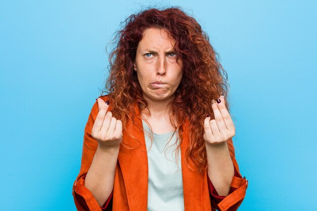 Young redhead elegant woman showing that she has no money.