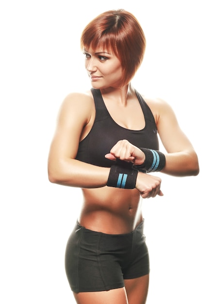 Young redhead female athlete wearing straps. White background, isolated, studio shot