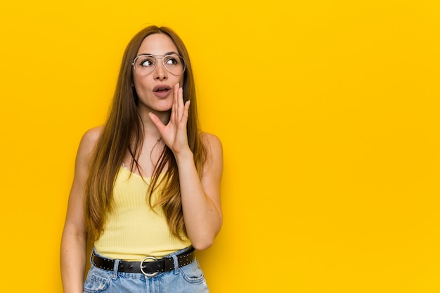 Young redhead ginger woman with freckless is saying a secret hot braking news and looking aside