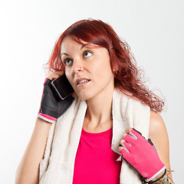 Young redhead girl talking on mobile over white background