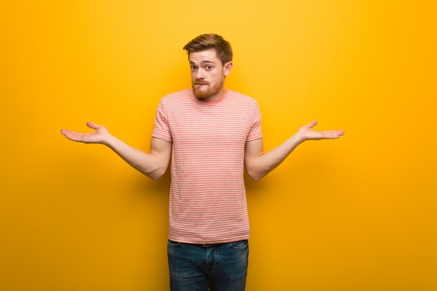 Photo young redhead man confused and doubtful