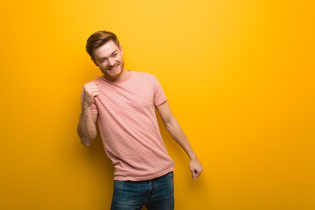 Young redhead man dancing and having fun