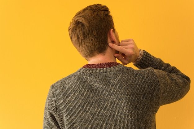 Young redhead man face closeup from behind thinking about something