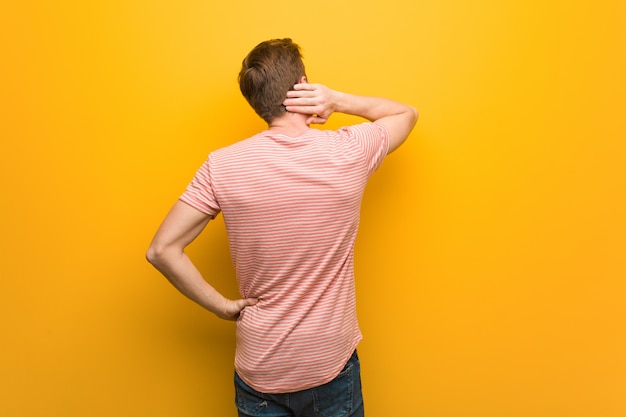 Young redhead man from behind thinking about something