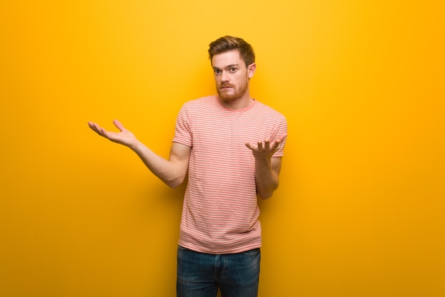 Young redhead man looking confused