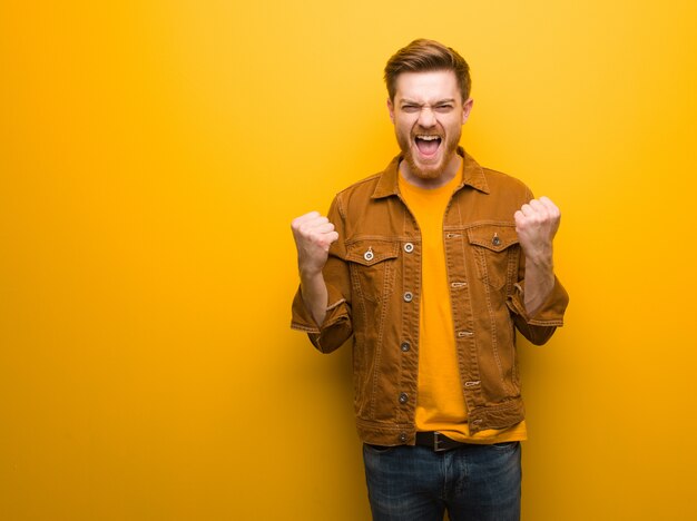 Young redhead man surprised and shocked