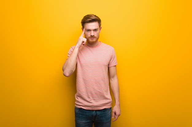 Young redhead man thinking about an idea