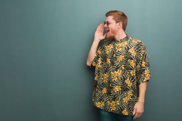 Photo young redhead man wearing exotic summer clothes whispering gossip undertone