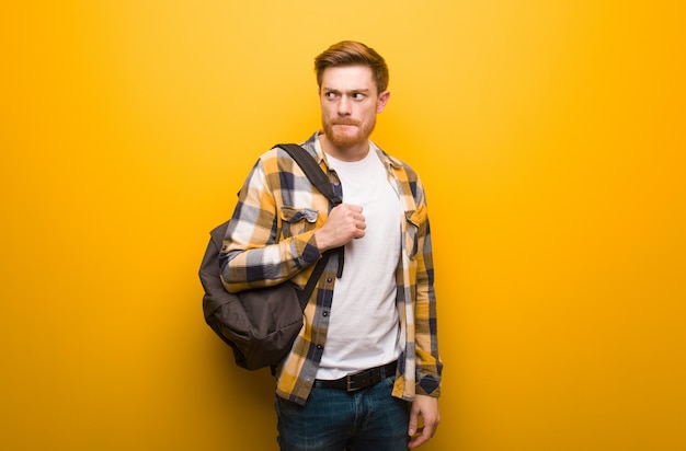 Young redhead student man thinking about an idea