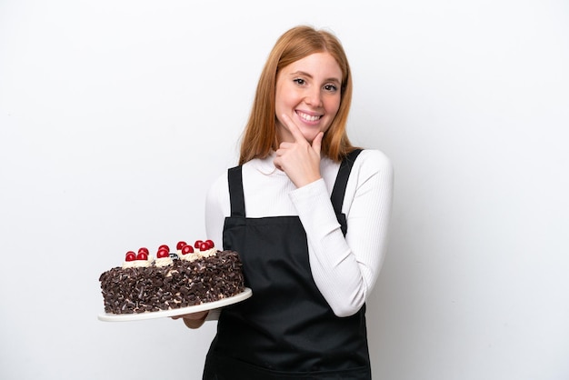 Young redhead woman holding birthday cake isolated on white background happy and smiling