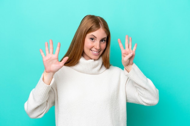 Young redhead woman isolated on blue background counting nine with fingers