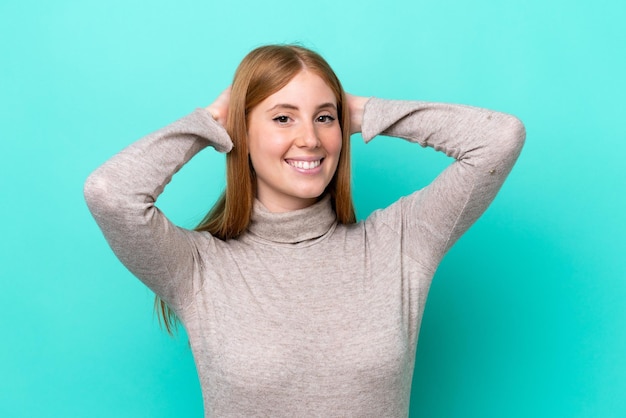 Young redhead woman isolated on blue background laughing