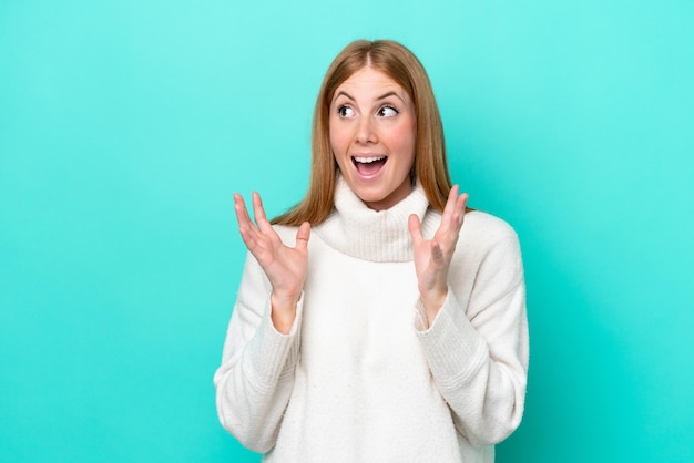 Young redhead woman isolated on blue background with surprise facial expression