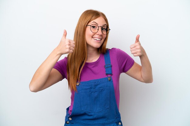 Young redhead woman isolated on white background giving a thumbs up gesture