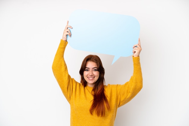 Young redhead woman isolated on white background holding an empty speech bubble