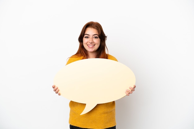 Young redhead woman isolated on white background holding an empty speech bubble