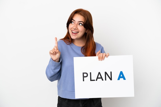 Young redhead woman isolated on white background holding a placard with the message PLAN A and thinking