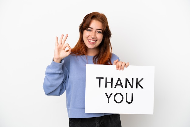 Photo young redhead woman isolated on white background holding a placard with text thank you with ok sign