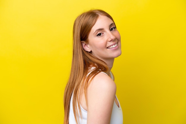 Young redhead woman isolated on yellow background Portrait